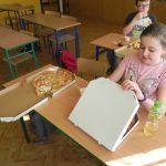 dziewczynka otwiera nowe opakowanie z pizzą