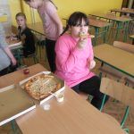 dziewczynka degustuje pizzę z sosem czosnkowym