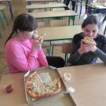 dziewczynki delektują się pizzą