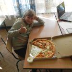 szczęśliwa dziewczynka siedzi obok zjedzonej pizzy