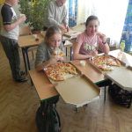 dzieci delektują się pizzą